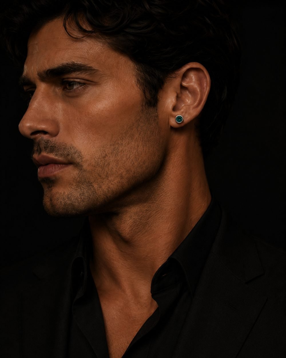 Man in profile wearing an emerald stud earring — The Shadow Edit, men's earrings