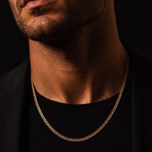 Adult male model wearing a 14K yellow gold 18-inch Miami Cuban curb chain in a dark luxury studio.