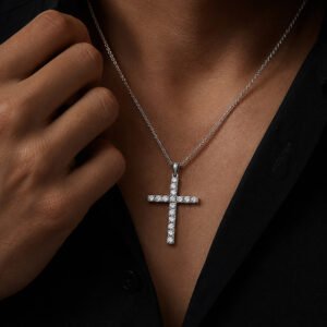 Adult male model wearing The Saint Diamond Cross — a 14K white gold lab-grown diamond cross necklace in a dark luxury studio.
