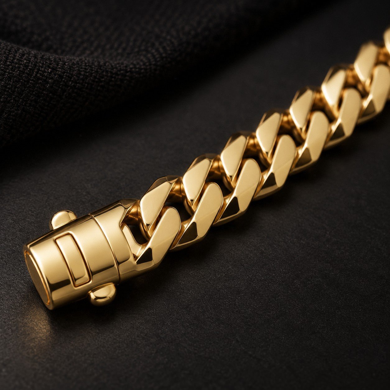Dark studio close-up of the polished curb links and push-tube clasp on the Monaco Edge bracelet.