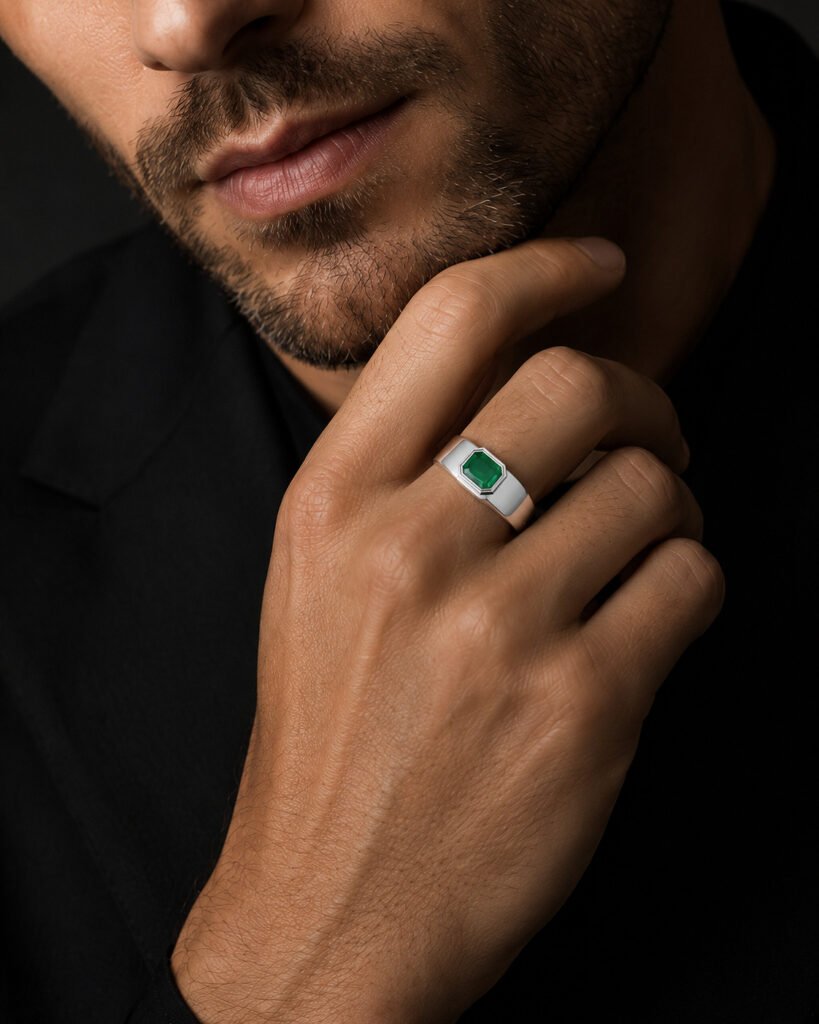 The Dominion Ring — 14K white gold men's ring with bezel-set emerald on a male model